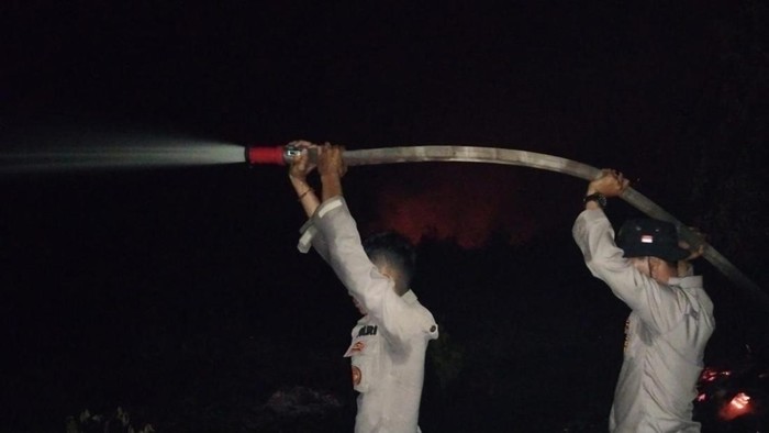 Polisi saat memadamkan api. (Foto: Dok Polsek Pangkalan Kerinci)