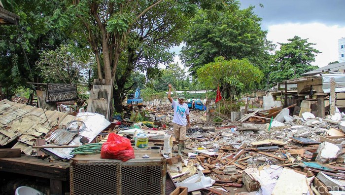 Penertiban bangunan warga berlangsung di TPU Kebon Nanas, Rabu (28/1/2026). Warga berupaya menyelamatkan barang di antara puing bangunan.