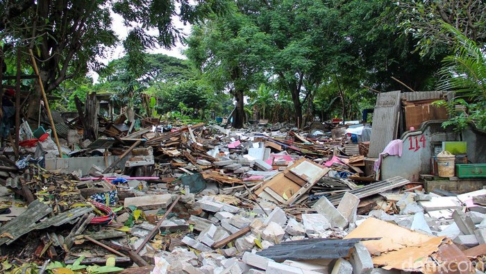 Penertiban bangunan warga berlangsung di TPU Kebon Nanas, Rabu (28/1/2026). Warga berupaya menyelamatkan barang di antara puing bangunan.