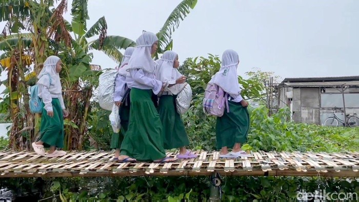 Warga terdampak luapan sungai Bengawan Jero Lamongan membuat jembatan bambu