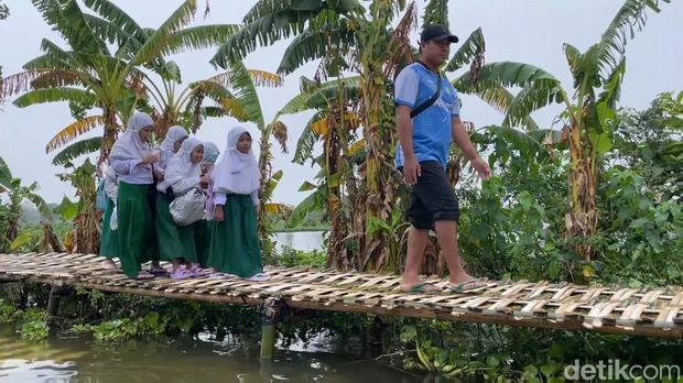 Warga yang dusunnya masih terdampak banjir luapan Bengawan Jero di Lamongan membangun jembatan secara swadaya dan bergotong-royong.