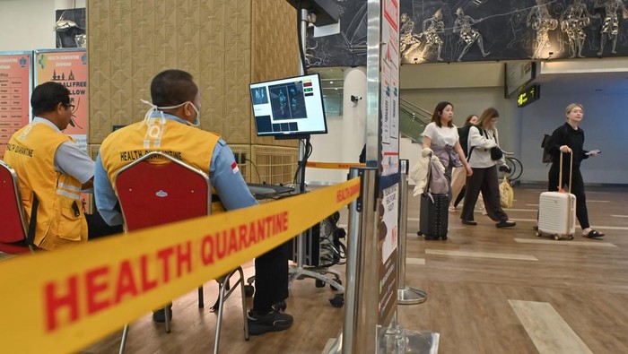 Petugas Balai Besar Kekarantinaan Kesehatan Kelas I Denpasar memantau suhu tubuh penumpang menggunakan alat pemindai suhu tubuh yang terpasang di Terminal Internasional Bandara Internasional I Gusti Ngurah Rai, Badung, Bali, Kamis (29/1/2026). Pengelola Bandara Bali bersama dengan instansi terkait melakukan pengawasan secara ketat dan menyeluruh terhadap penumpang yang tiba di Bali dengan memasang sejumlah alat thermal scanner di area kedatangan internasional dan domestik guna mencegah penularan virus Nipah. ANTARA FOTO/Fikri Yusuf/rwa.