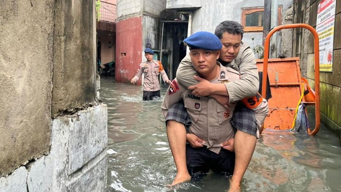 Brimob Polda Metro Gendong Warga Sakit yang Terjebak Banjir di Jakbar