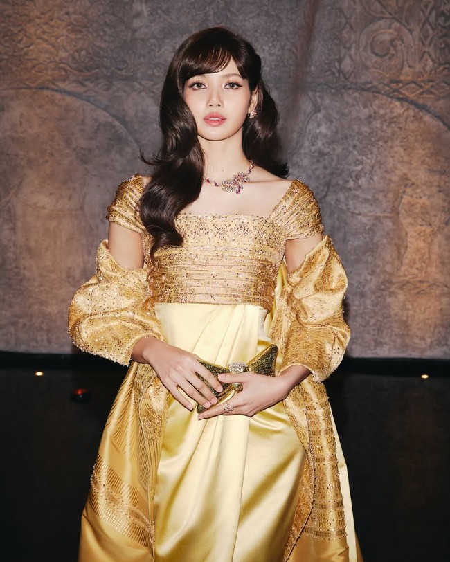 Untuk melengkapi penampilannya, Lisa BLACKPINK memakai anting dan kalung Bvlgari bertatahkan berlian dan rubi. Sementara clutch emas berbentuk pita yang ia kenakan datang dari label fashion Thailand, Jasmina Collection. Foto: dok. Instagram @lalalalisa_m