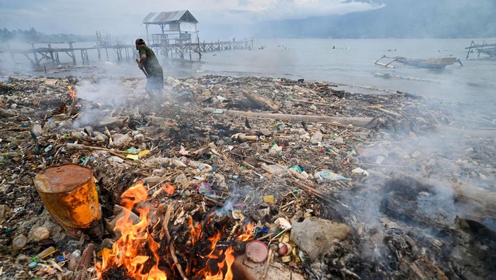 Warga mengumpulkan dan membakar sampah laut kiriman di pesisir Pantai Tondo, Teluk Palu, Palu, Sulawesi Tengah, Kamis (29/1/2026). Sampah yang memenuhi pesisir itu adalah kiriman dari luar pulau yang masuk ke kawasan teluk secara periodik selama periode Desember hingga Januari dan sulit dihindari karena menjadi siklus tahunan setiap musim angin barat. ANTARA FOTO/Basri Marzuki