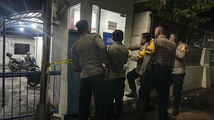Petugas kepolisian saat memasang garis polisi pada tempat mesin ATM di Jalan Sudirman, Kecamatan/Kabupaten Wonogiri, Rabu (28/1/2026) malam.