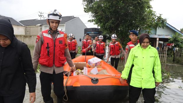 Polisi turun mengevakuasi korban banjir di sejumlah desa di wilayah Kabupaten Bekasi, Jawa Barat, Kamis (29/1/2026).