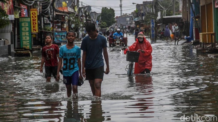 Sejumlah warga berjalan menerobos banjir yang merendam kawasan Perumahan Pondok Ungu Permai, Kabupaten Bekasi, Jawa Barat, Kamis (29/1/2026).