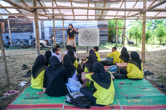 Seorang guru memberikan materi pelajaran di sekolah darurat gabungan PAUD, SD dan SMP di Balai Desa Agusen, Blangkejeren, Kabupaten Gayo Lues, Aceh, Kamis (29/1/2026). Masyarakat Desa Agusen menginisiasi untuk membangun sekolah darurat sementara akibat hancurnya infrastruktur saat banjir bandang yang terjadi akhir November 2025 lalu. ANTARA FOTO/Raisan Al Farisi/rwa.