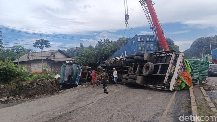 Evakausi truk yang melintang akibat terguling usai menabrak dua kendaraan di  jalur Pantura di Jalan Raya Desa Surodadi, Kecamatan Gringsing, Batang,  Jumat (30/1)