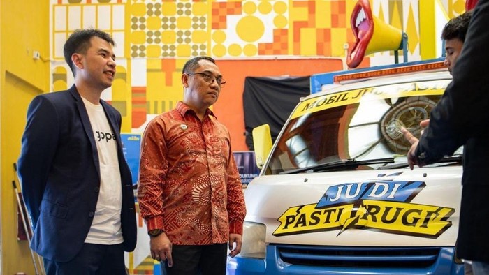 Head of GoPay Wallet, Kelvin Timotius (kiri) bersama, Alexander Sabar, Dirjen Pengawasan Ruang Digital Komdigi berfoto bersama di depan Van Judi Pasti Rugi