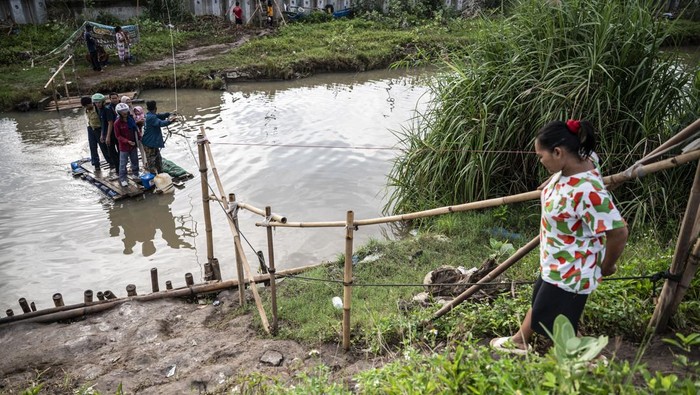 Sejumlah warga menyeberangi Sungai Beringin menggunakan rakit buatan di Mangkang Wetan, Tugu, Semarang, Jawa Tengah, Jumat (30/1/2026). Sejumlah warga setempat berharap Pemkot Semarang segera menindaklanjuti perbaikan jembatan, setelah selama sekitar dua pekan mereka terpaksa menyeberangi Sungai Beringin menggunakan rakit buatan swadaya masyarakat akibat jembatan penghubung ke Kampung Tambaksari ambrol diterjang banjir pada Kamis (15/1). ANTARA FOTO/Aprillio Akbar/foc.