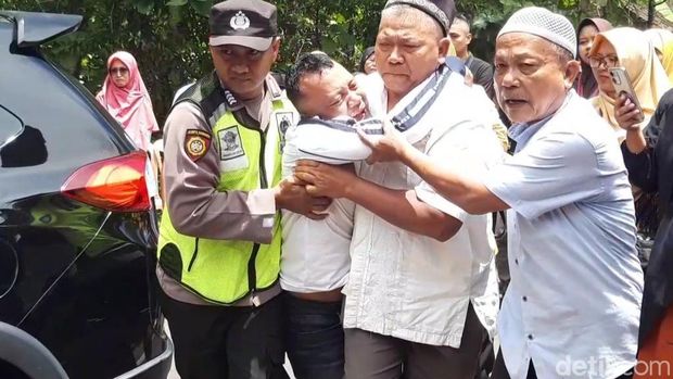 Purwanto (dua dari kiri) harus dipapah polisi saat tiba di Desa Pengkol, Karanggede, Boyolali, Jumat (301/2026). Istrinya terluka dan anaknya tewas jadi korban rampok sadis.