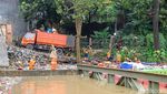 Aksi Petugas DLH Bersihkan Sampah Sungai Ciliwung untuk Jaga Aliran Air