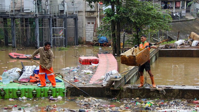 Petugas UPK Badan Air DLH DKI Jakarta membersihkan tumpukan sampah di Sungai Ciliwung, Jakarta Timur, Jumat (30/1/2026). Sampah dinilai menghambat aliran air sungai.