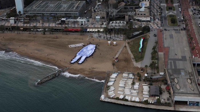 Aktivis membentangkan potret raksasa Hind Rajab, gadis Palestina berusia lima tahun yang tewas di Gaza, di pantai Barcelona sebagai seruan perlindungan anak sipil. REUTERS/Nacho Doce