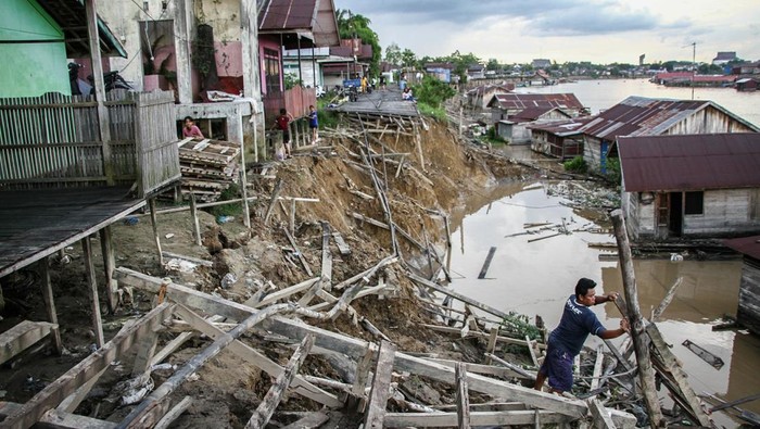 Seorang warga membuat titian jalan menuju rumahnya yang terdampak ambruknya jalan akibat abrasi di kawasan permukiman bantaran Sungai Kahayan, Palangka Raya, Kalimantan Tengah, Sabtu (31/1/2026). Abrasi yang mengakibatkan terputusnya jalan permukiman warga yang terbuat dari kayu tersebut disebabkan tingginya intensitas hujan yang terjadi pada Jumat (30/1) dan Badan Penanggulangan Bencana Daerah (BPBD) Kota Palangka menghimbau warga sekitar bantaran Sungai Kahayan untuk waspada dikhawatirkan ada abrasi susulan. ANTARA FOTO/Auliya Rahman/nz