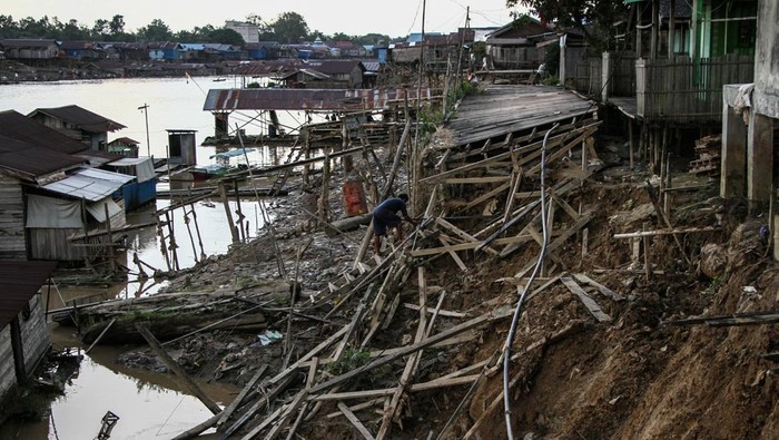 Seorang warga membuat titian jalan menuju rumahnya yang terdampak ambruknya jalan akibat abrasi di kawasan permukiman bantaran Sungai Kahayan, Palangka Raya, Kalimantan Tengah, Sabtu (31/1/2026). Abrasi yang mengakibatkan terputusnya jalan permukiman warga yang terbuat dari kayu tersebut disebabkan tingginya intensitas hujan yang terjadi pada Jumat (30/1) dan Badan Penanggulangan Bencana Daerah (BPBD) Kota Palangka menghimbau warga sekitar bantaran Sungai Kahayan untuk waspada dikhawatirkan ada abrasi susulan. ANTARA FOTO/Auliya Rahman/nz