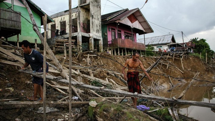 Seorang warga membuat titian jalan menuju rumahnya yang terdampak ambruknya jalan akibat abrasi di kawasan permukiman bantaran Sungai Kahayan, Palangka Raya, Kalimantan Tengah, Sabtu (31/1/2026). Abrasi yang mengakibatkan terputusnya jalan permukiman warga yang terbuat dari kayu tersebut disebabkan tingginya intensitas hujan yang terjadi pada Jumat (30/1) dan Badan Penanggulangan Bencana Daerah (BPBD) Kota Palangka menghimbau warga sekitar bantaran Sungai Kahayan untuk waspada dikhawatirkan ada abrasi susulan. ANTARA FOTO/Auliya Rahman/nz