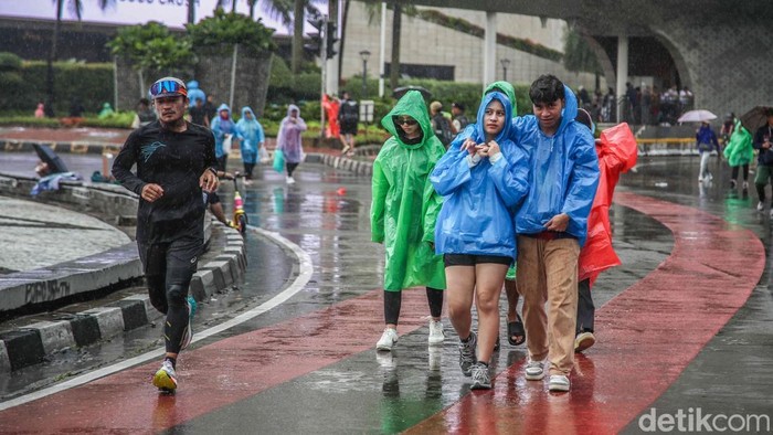 Gerimis yang turun sejak pagi tak menyurutkan langkah warga yang memadati kawasan Car Free Day Bundaran HI, Jakarta Pusat, Minggu (1/2/2026).