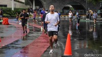 Gerimis yang turun sejak pagi tak menyurutkan langkah warga yang memadati kawasan Car Free Day Bundaran HI, Jakarta Pusat, Minggu (1/2/2026).