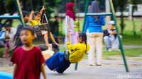 Anak-anak bermain ayunan di area playground Lapangan Banteng, Jakarta, Minggu (1/2/2026). Fasilitas ramah keluarga ini menjadi salah satu daya tarik utama bagi orang tua yang mengajak buah hati menghabiskan waktu akhir pekan di ruang terbuka.