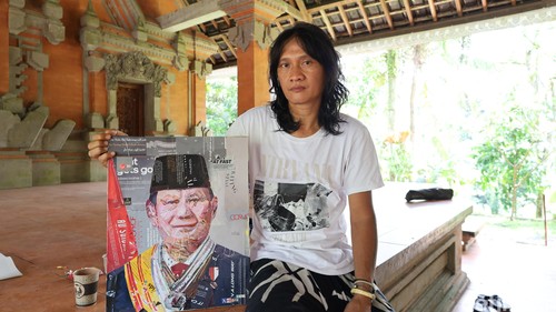 Nyoman Antara menunjukkan karyanya berupa lukisan kolase foto diri Presiden RI Prabowo Subianto pesanan Kementerian ESDM di pameran Humanity Pura Goa Gajah, Gianyar, Sabtu (31/1/2026). (Aryo Mahendro/detikBali).