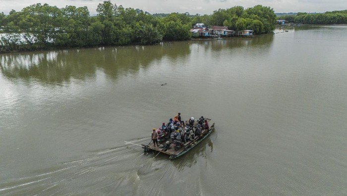 Foto udara warga bersama kendaraanya menaiki perahu tradisional (jolloro) melintasi sungai Tallo di Kecamatan Tallo Makassar, Sulawesi Selatan, Minggu (1/2/2026). Jasa penyeberangan perahu jolloro dengan tarif Rp3 ribu per orang tersebut mayoritas digunakan oleh masyarakat Pulau Lakkang sebagai alternatif transportasi utama dengan melintasi Sungai Tallo menuju ke Kota Makassar untuk mempersingkat waktu serta jarak tempuh. ANTARA FOTO/Andri Saputra/foc.