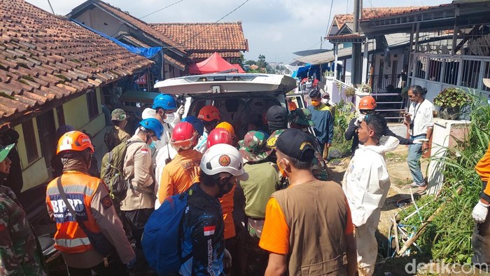 petugas mengevakuasi jasad korban tertimbun longsor menuju ambulans