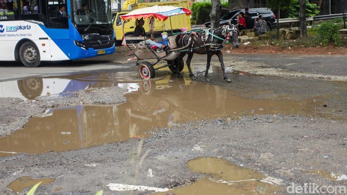 Sejumlah pengendara melintas di Jalan Mitra Bahari, Jakarta Utara, Senin (2/2/2026), yang mengalami kerusakan parah dengan lubang di berbagai titik Lubang jalan yang banyak dan cukup dalam dinilai membahayakan keselamatan pengendara, terutama saat lalu lintas padat.