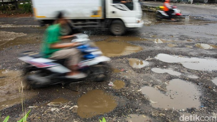 Sejumlah pengendara melintas di Jalan Mitra Bahari, Jakarta Utara, Senin (2/2/2026), yang mengalami kerusakan parah dengan lubang di berbagai titik Lubang jalan yang banyak dan cukup dalam dinilai membahayakan keselamatan pengendara, terutama saat lalu lintas padat.