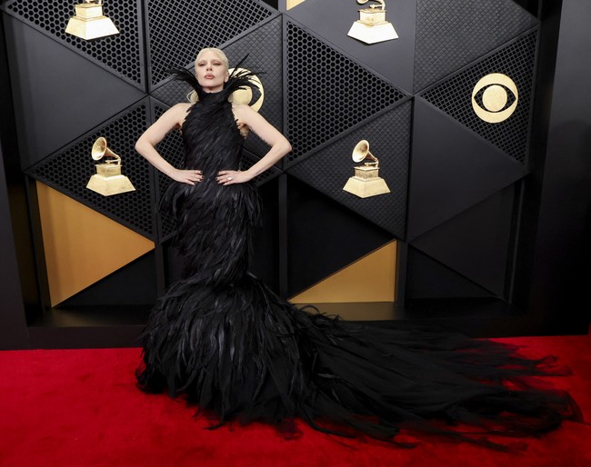 Bak angsa hitam, Lady Gaga mengenakan busana hitam berhiaskan bulu rancangan Matières Fécales yang membalut lekuk tubuh jam pasirnya dengan sempurna.Tampilan ini menampilkan kerah tinggi dengan bulu-bulu yang menjulang ke atas, membingkai wajahnya. Menyusuri bagian tubuh ke bawah, bulu-bulu tersebut kemudian melebar membentuk siluet putri duyung di bagian bawah gaun. (Foto: REUTERS/Mario Anzuoni)