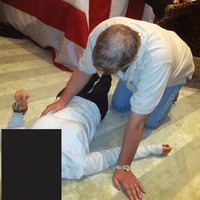 Wajah perempuan tersebut disamarkan. Foto lain menunjukkan tangan Andrew diletakkan di bagian perut orang yang sama. Di latar belakang, terlihat kaki orang lain yang disandarkan ke atas meja dengan tumpukan handuk di atasnya. (Foto: U.S. Justice Department/Handout via REUTERS)