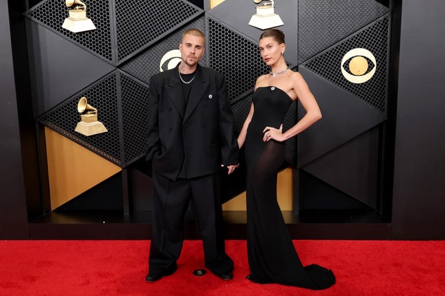 Mendampingi sang suami, model Hailey Bieber tampil cantik sekaligus seksi berbalut gaun hitam tanpa tali dari Alaïa. Ibu satu anak ini juga mengenakan pin ‘ICE out’ dan melengkapi penampilannya dengan kalung choker serta anting berlian. Foto: Getty Images via AFP/AMY SUSSMAN