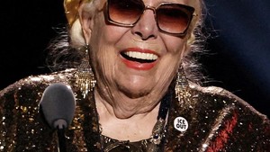 Legenda folk Joni Mitchell turut mengenakan pin “ICE OUT” saat menerima Best Historical Album, memperlihatkan bahwa dukungan terhadap isu imigrasi menjangkau lintas generasi musisi. REUTERS/Daniel Cole