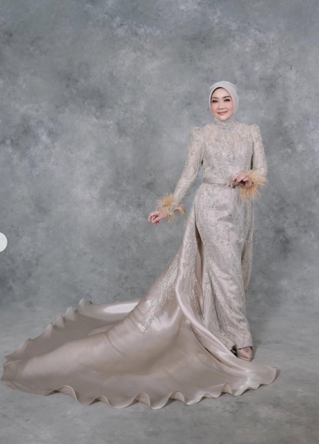 Penampilan Atalia kian anggun dengan ekor gaun yang panjang, terbuat dari bahan satin berwarna senada. Pada bagian ujung lengan juga terdapat aksen bulu halus berwarna coklat yang menambah sentuhan unik. Foto: Instagram/@ataliapr