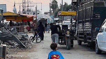 Seorang bocah Palestina, yang telah menyaksikan lebih banyak teror daripada yang pernah dialami kebanyakan orang dewasa di luar Gaza, berkeliaran di jalanan mengenakan kostum Superman. Foto: Boredpanda