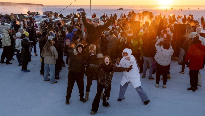 People dance to the tunes of a DJ on the ice covering the Kyiv Sea, a hydroelectric reservoir on the Dnipro River, as the city experiences widespread power and heating outages following recent Russian strikes on the capital's civilian infrastructure, amid Russia's attack on Ukraine, during sunset in Kyiv, Ukraine February 1, 2026. REUTERS/Thomas Peter   REFILE - CORRECTING DATE FROM 