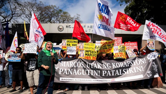 An activist holds a placard during a protest calling for the impeachment of Philippine President Ferdinand Marcos Jr. as a Philippine house panel weighs on the merits of the complaints, outside the House of Representatives in Quezon City, Philippines, February 4, 2026. REUTERS/Lisa Marie David
