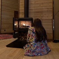 Setelah masuk ke dalam penginapan, Lisa BLACKPINK langsung menghangatkan diri memakai hoodie dan celana Takashi Murakami dengan desain bunga ikonik, duduk di depan perapian. Foto: dok. Instagram @lalalalisa_m