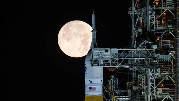 A full moon is seen shining over NASA's SLS (Space Launch System) and Orion spacecraft, atop the mobile launcher in the early hours of Sunday, Feb. 1, 2026, at NASA's Kennedy Space Center in Florida. (Sam Lott/NASA via AP)