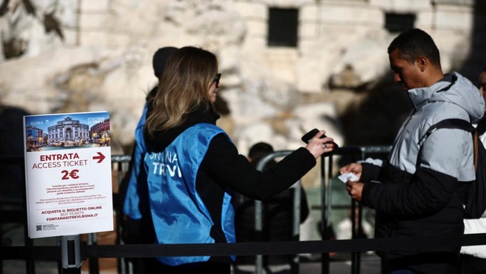 Tourists access the viewing area of the Trevi Fountain in Rome, after the city introduces a two-euro paid entry at several monuments and museums previously free, in Rome, Italy, February 2, 2026. REUTERS/Vincenzo Livieri     TPX IMAGES OF THE DAY