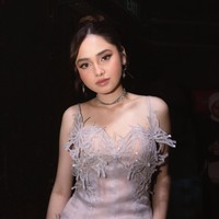 Penampilan Syifa itu diunggah oleh desainer dress yang dikenakannya, KRINOU. Gaun mini berwarna nude dan abu-abu keperakan itu memiliki potongan sleeveless dengan tali tipis. Silhouette fitted yang mengikuti bentuk tubuh memberikan kesan ramping. Foto: Instagram/@krinouofficial