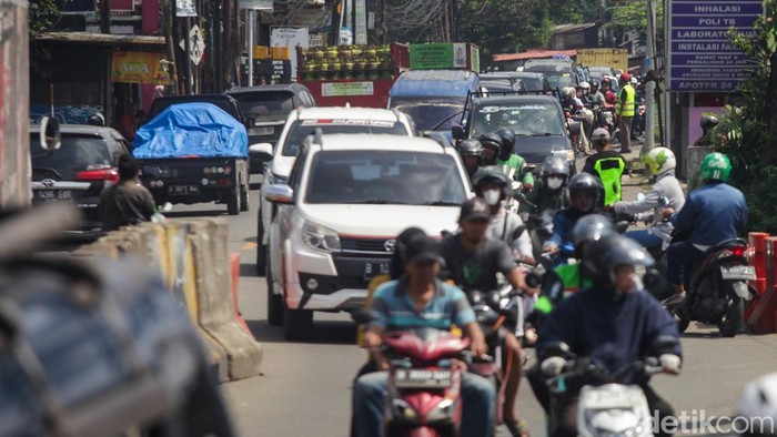 Sebuah truk pengangkut pasir mengalami mogok akibat ban pecah saat melintasi Tanjakan Yapan di Jalan Raya Muchtar, Kota Depok, Jawa Barat, Kamis (5/2/2026). Posisi truk yang menutup sebagian badan jalan menyebabkan arus lalu lintas tersendat dan kendaraan dari dua arah harus melintas secara bergantian.