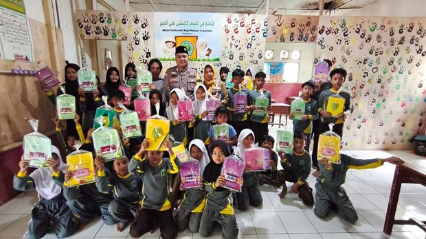 Bhabinkamtibmas Polsek Mande, Polres Cianjur, Bripka Bayu Angga Kusumanegara mengajar Bahasa Inggris kepada siswa Madrasah Ibtidaiyah (MI) Al Jihad.