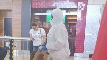 Seorang perempuan mengenakan hazmat suit lengkap namun tetap memakai sepatu hak tinggi—potret kontras antara ketakutan dan gaya hidup. Foto: Boredpanda