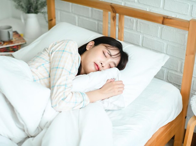 Asian woman sleeping, high angle view of beautiful young woman lying in bed and keeping eyes closed