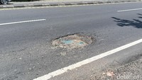 Terlihat lubang terisi oleh sampah yang sudah tergerus roda kendaraan. Seperti ini merupakan langkah antisipatif dari warga untuk mengurangi kedalaman lubang tersebut.  