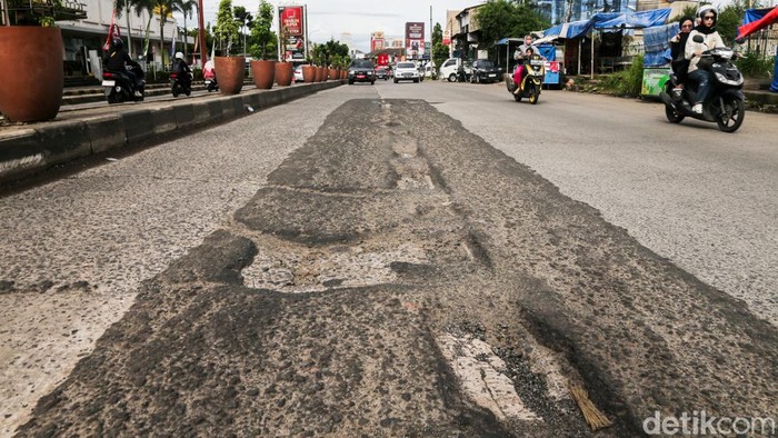 Pengendara melintas di Jalan Siliwangi Raya, Pamulang, Tangerang Selatan, Banten, Jumat (6/2/2026). Kondisi jalan berlubang berpotensi memicu kecelakaan lalu lintas jika pengendara tidak berhati-hati.