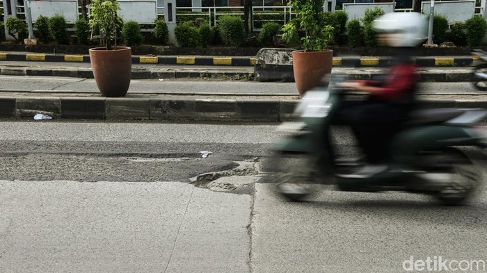 Pengendara melintas di Jalan Siliwangi Raya, Pamulang, Tangerang Selatan, Banten, Jumat (6/2/2026). Kondisi jalan berlubang berpotensi memicu kecelakaan lalu lintas jika pengendara tidak berhati-hati.